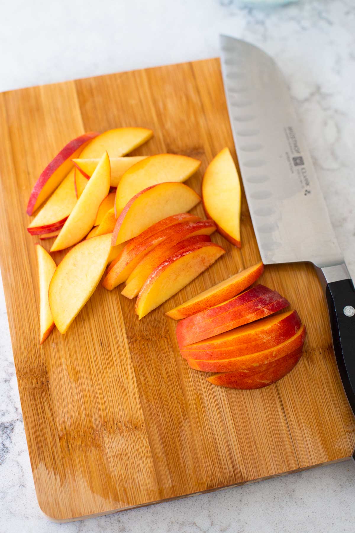 A fresh peach has been sliced into thin slices.