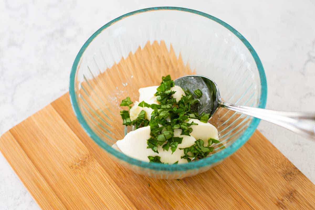 The ricotta and basil have been added to a bowl for mixing.