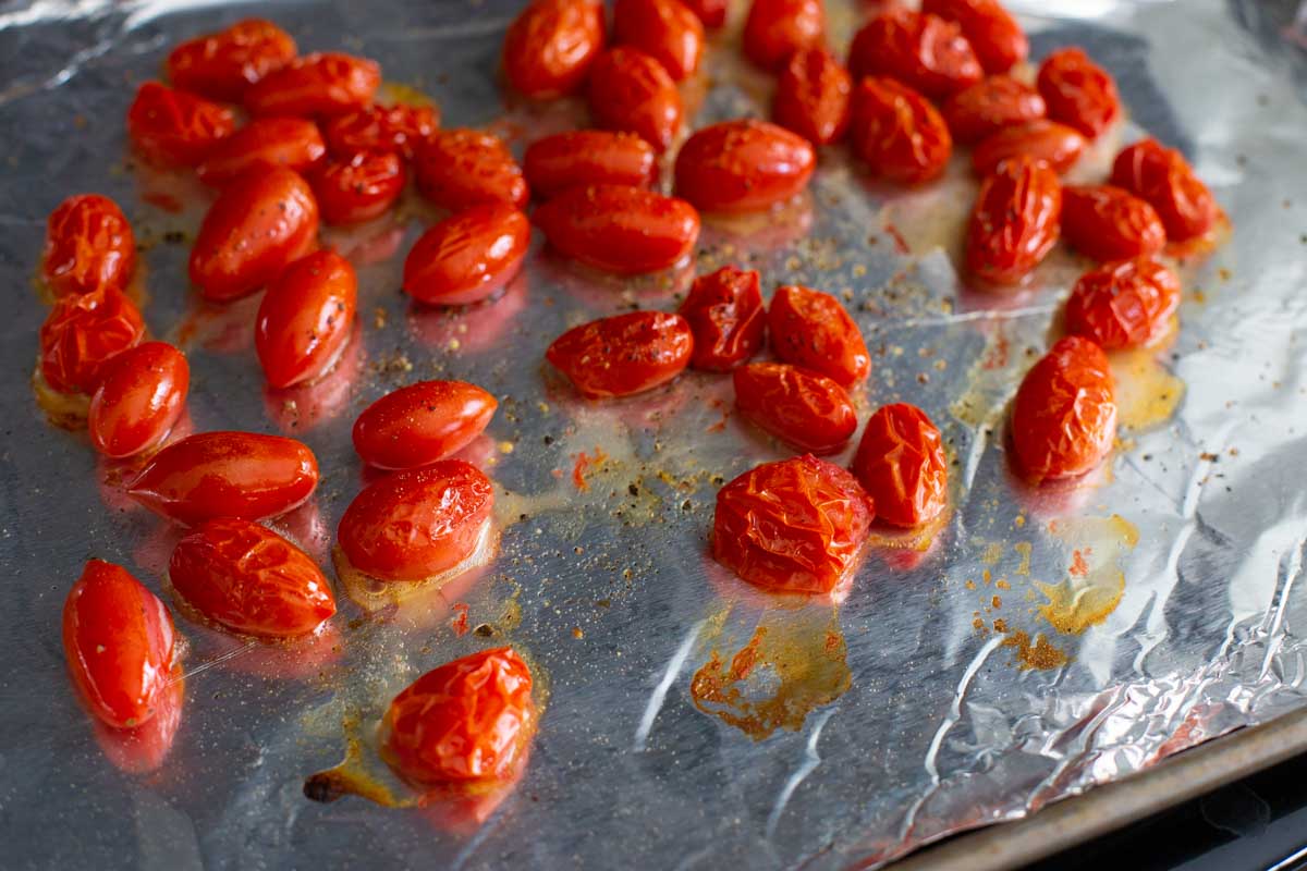 The cherry tomatoes are finished roasting and are slightly wrinkled.