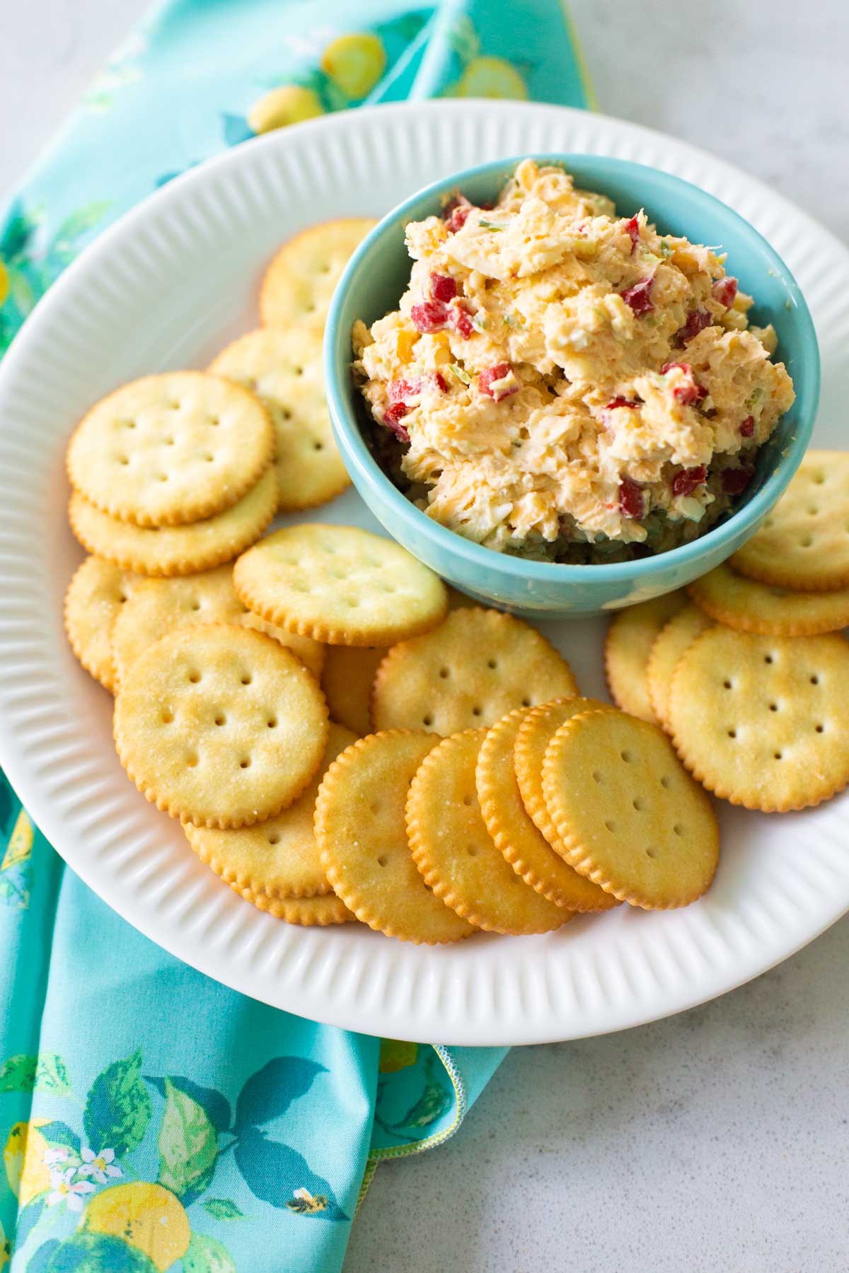 Plate of crackers with a serving of pimento cheese in a bowl.