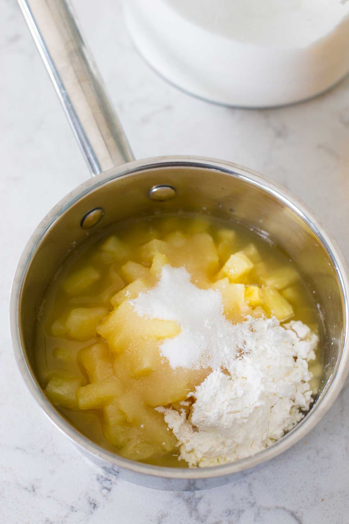 The pineapple filling ingredients are all added to a small saucepan.