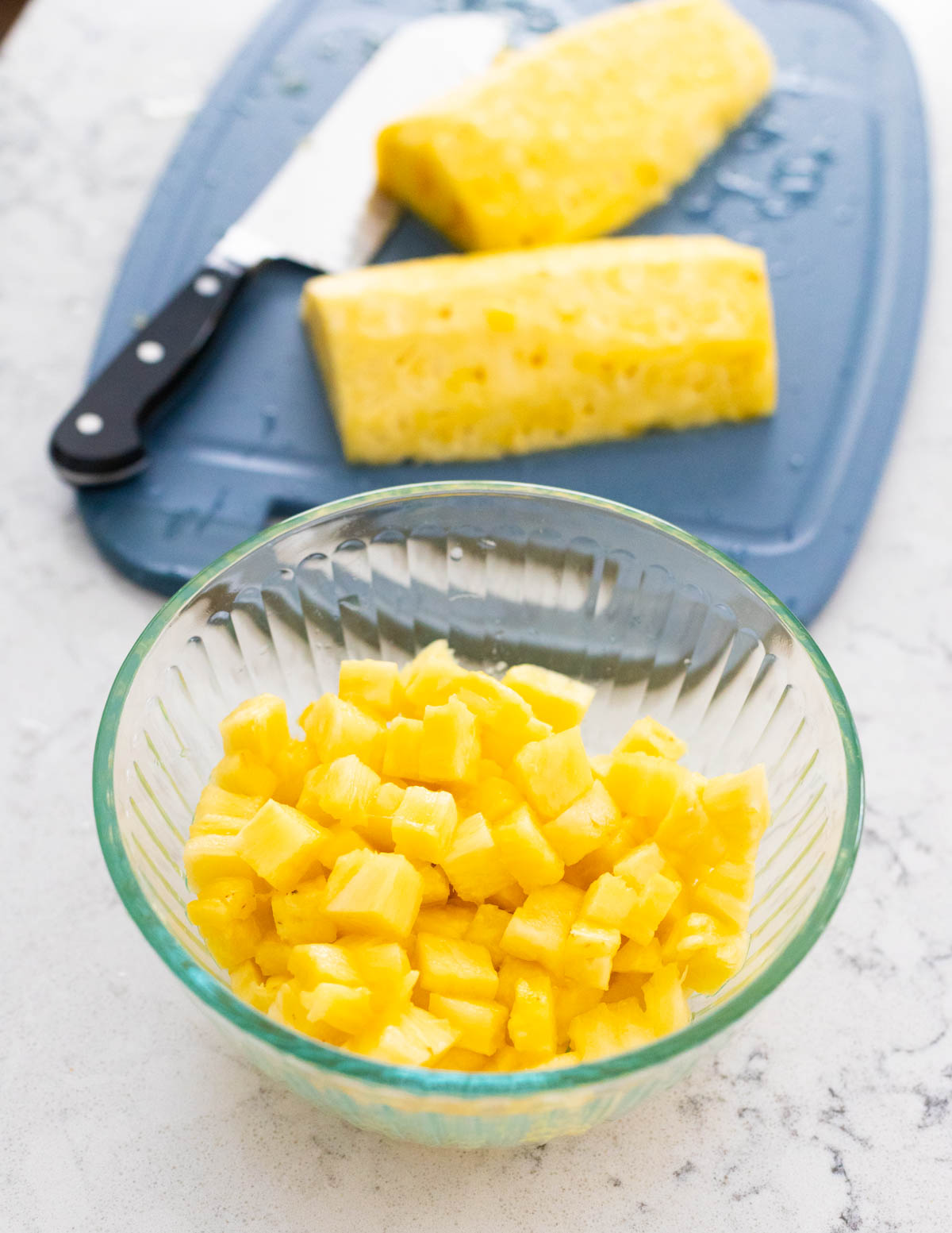 The fresh pineapple has been chopped and placed in a bowl.
