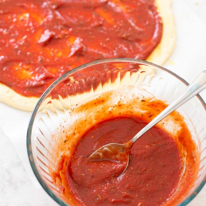 A tomato pizza sauce is being mixed in a bowl.
