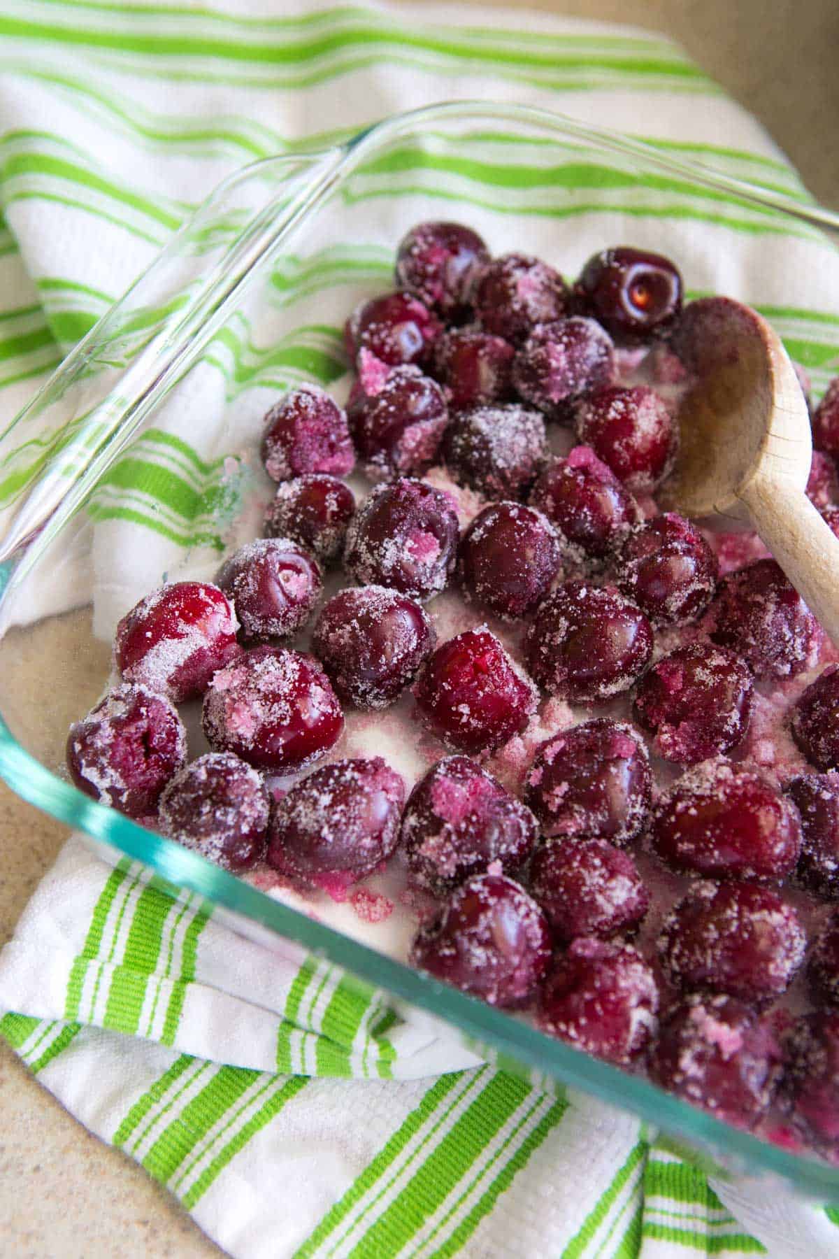 The cherries have been tossed in sugar and are ready to be roasted in a baking dish.