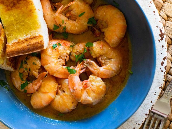 A big bowl of buttery shrimp with garlic bread for dunking.