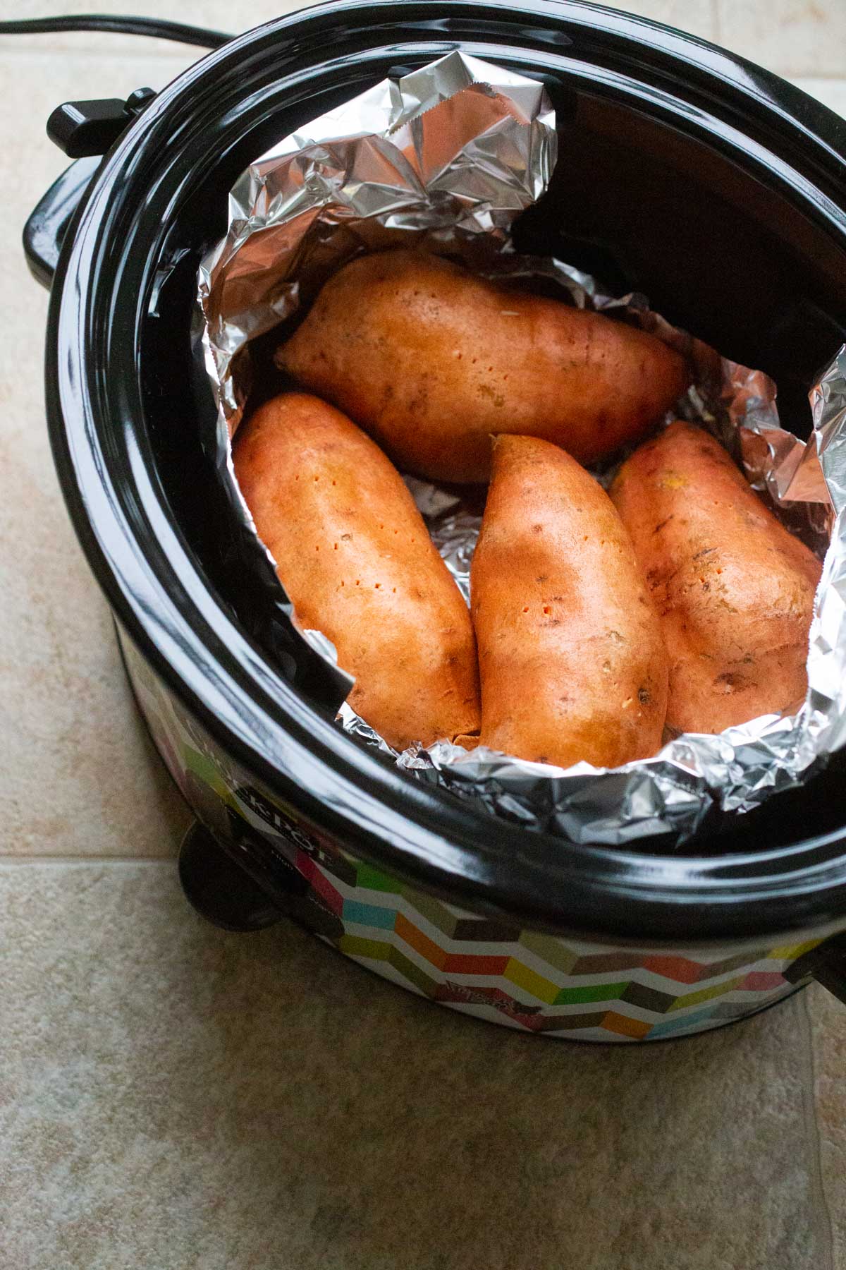 A crockpot with sweet potatoes inside.