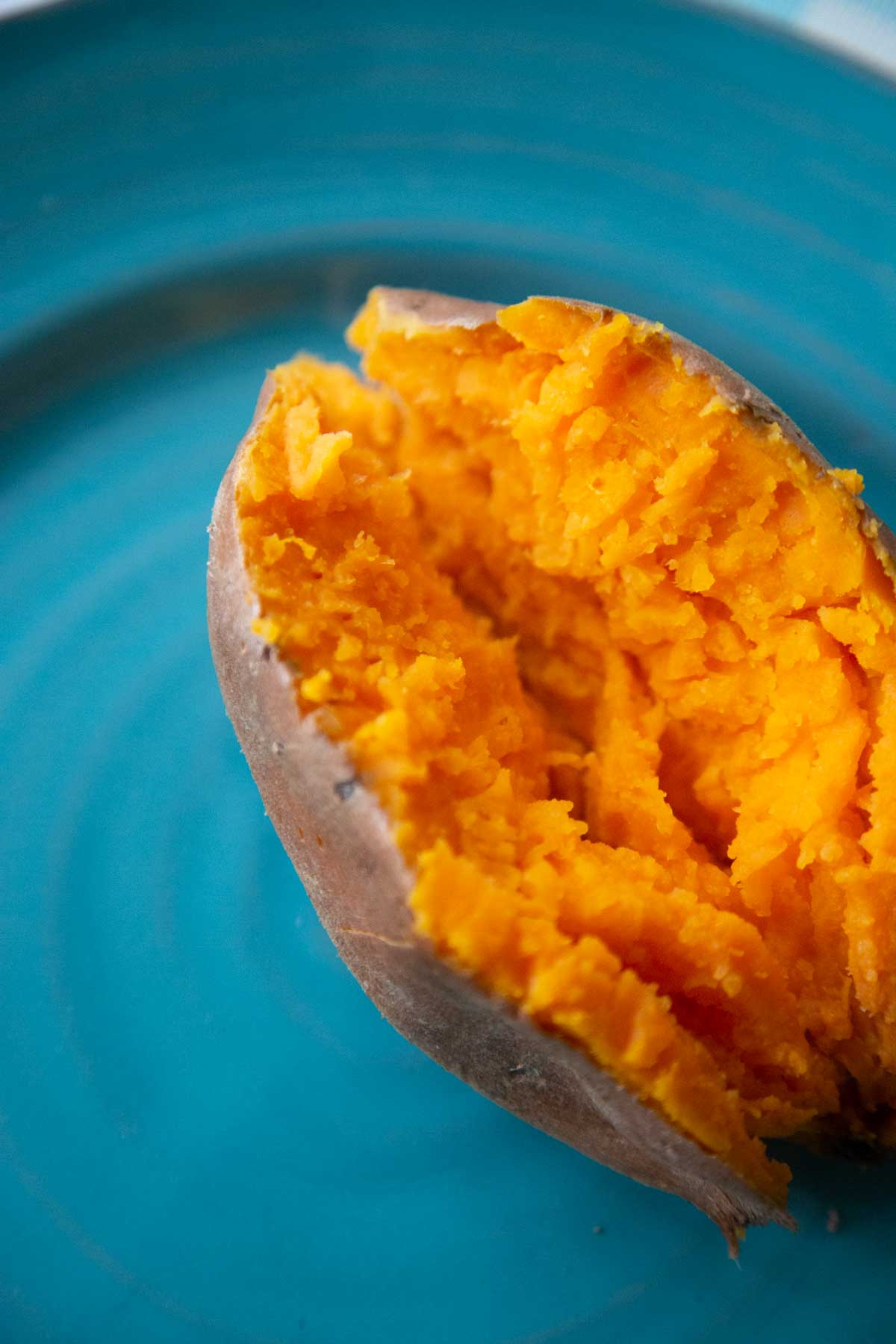 A baked sweet potato has been split open to show how to top it.