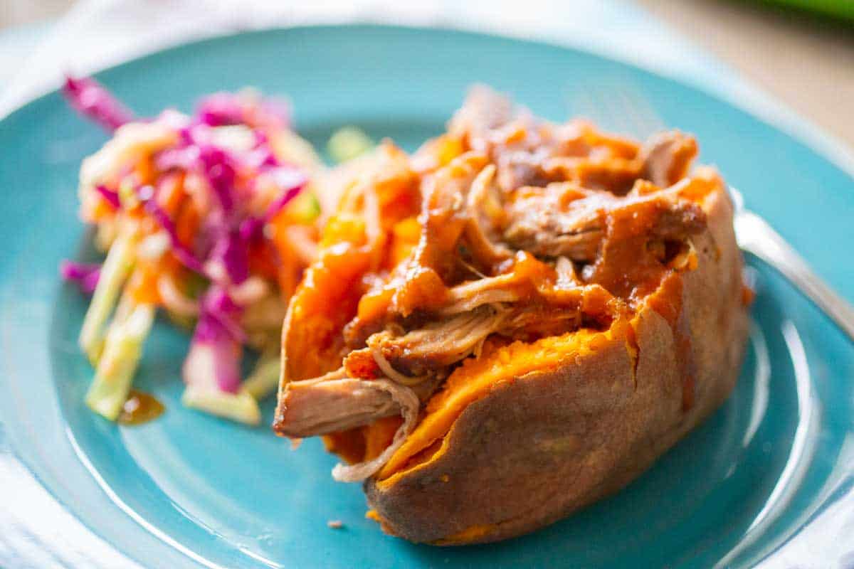 A stuffed sweet potato filled with BBQ pork.