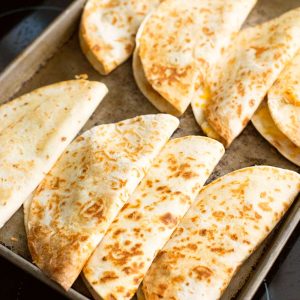 A baking tray filled with baked quesadillas.