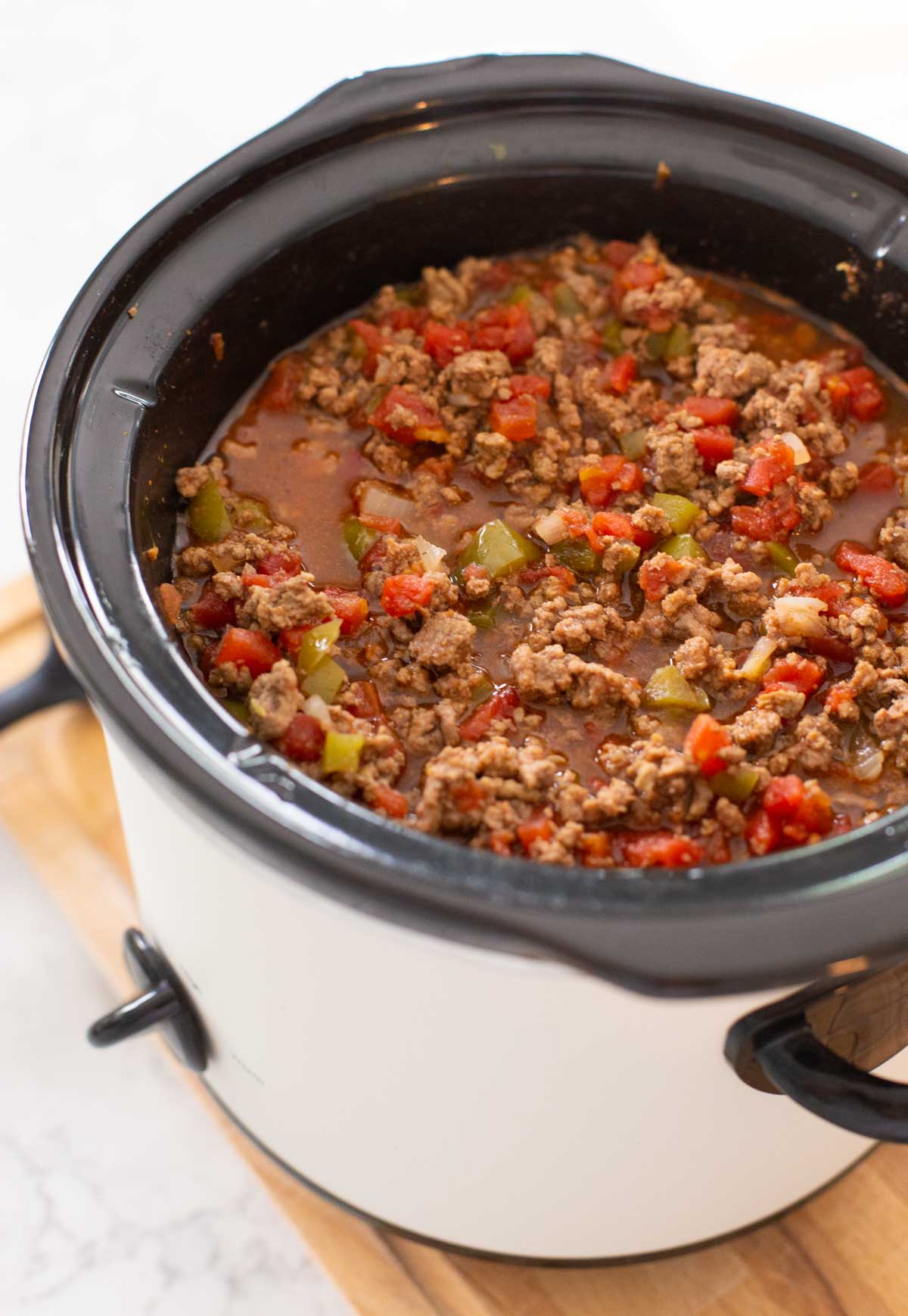 The cooked sloppy joe mix is ready to be served warm from inside the crockpot.