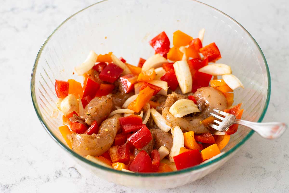 The mixing bowl shows the chicken and vegetables tossed together and seasoned.