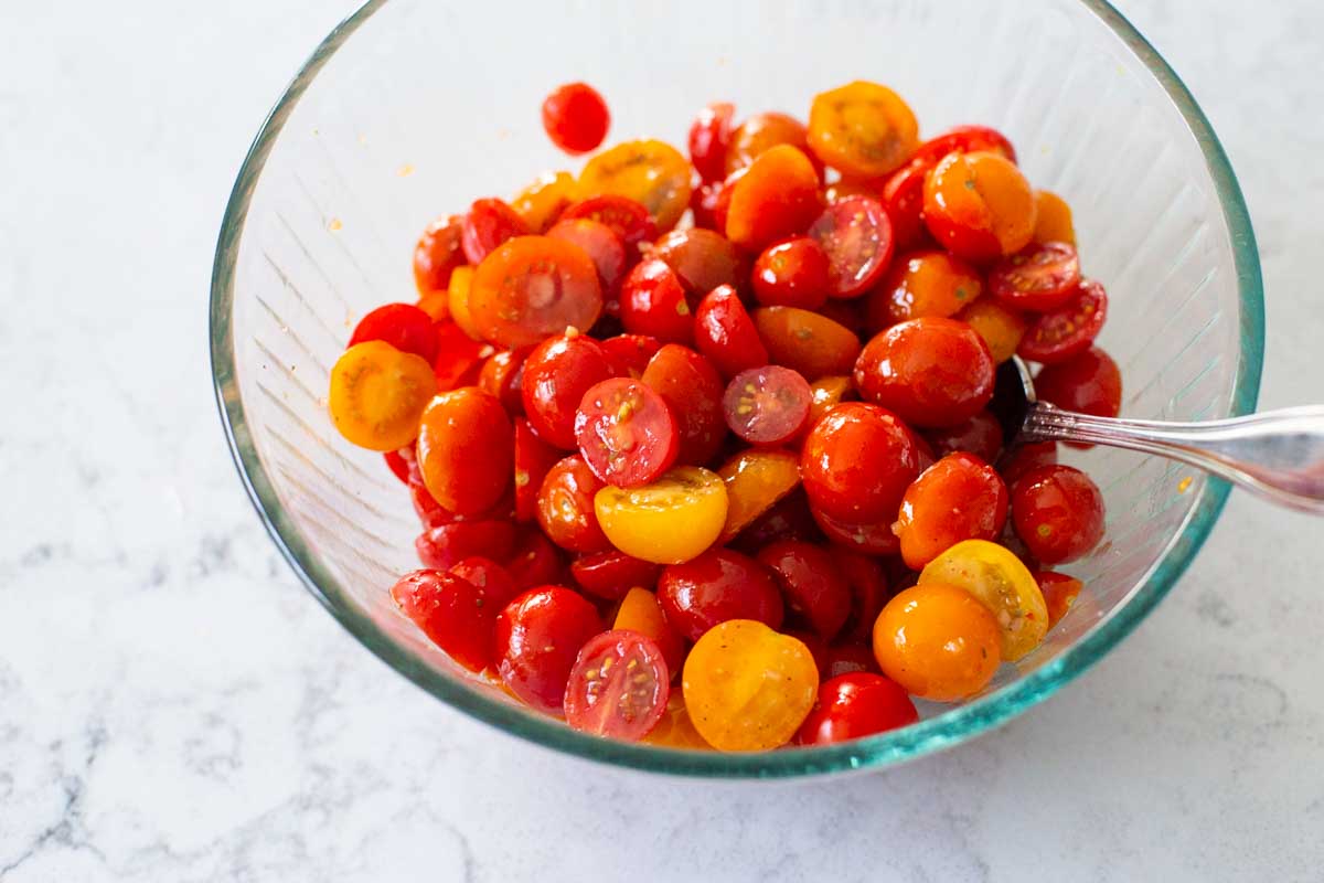 Toss the tomatoes in the dressing in a medium mixing bowl.