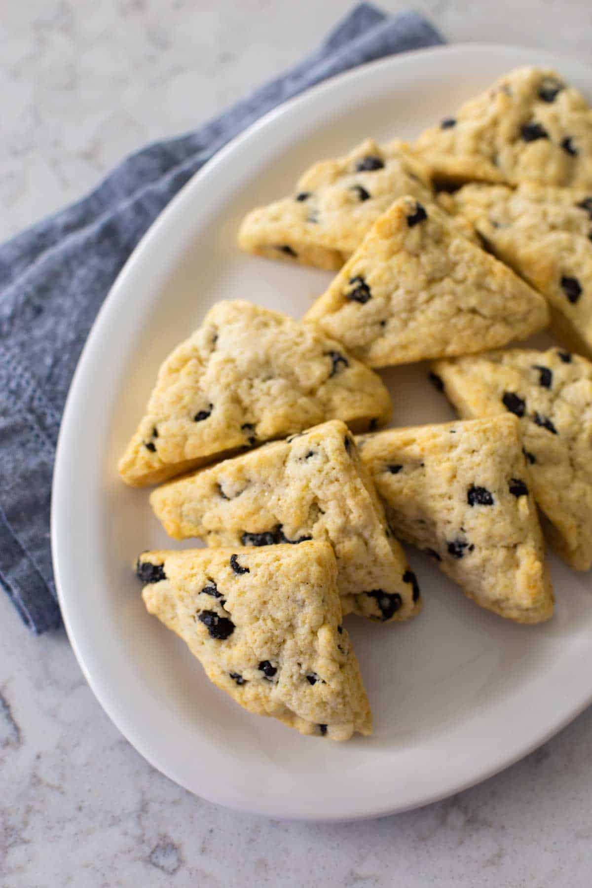 A platter of blueberry scones with a blue napkin.