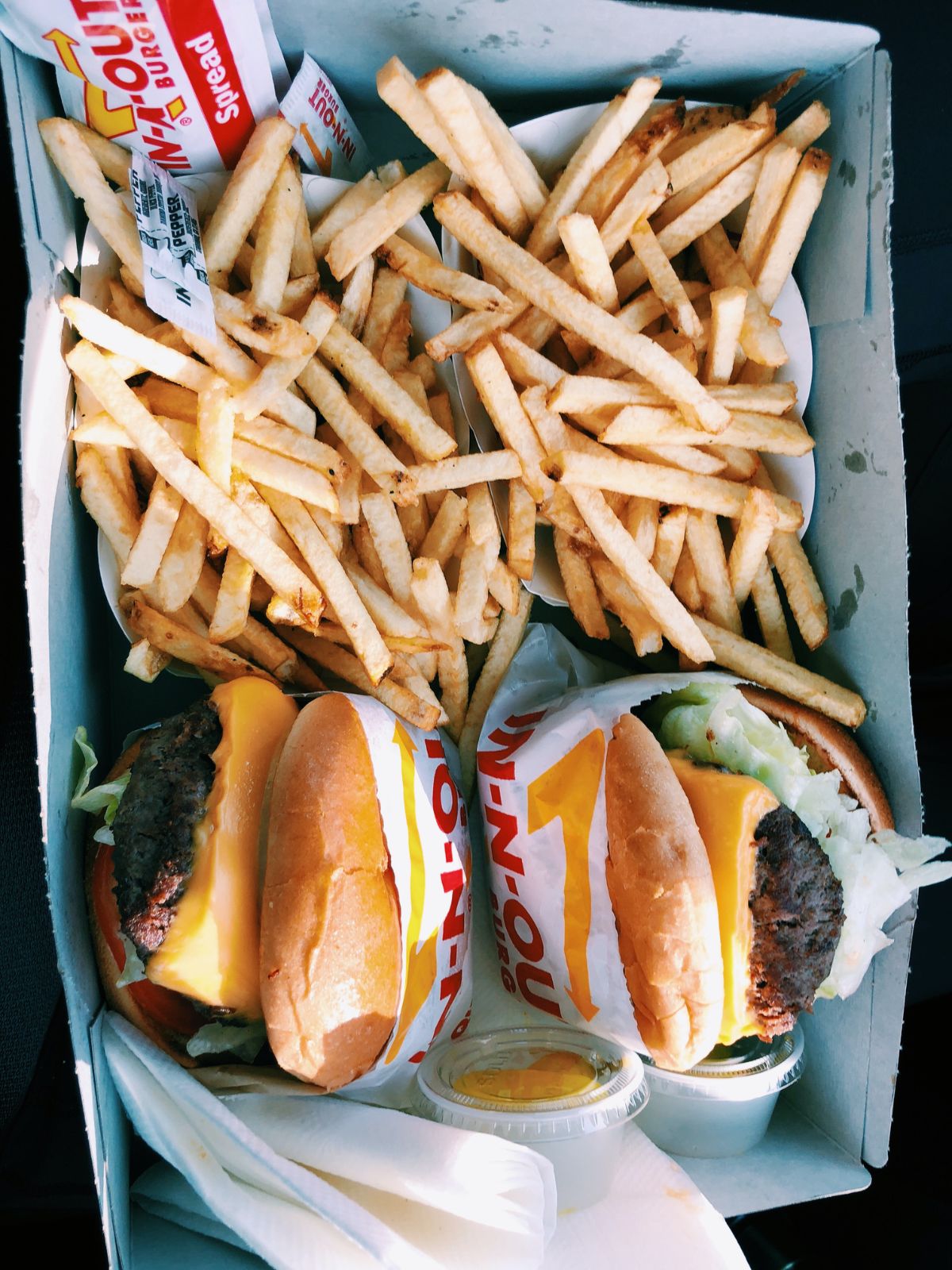 Take out burgers and fries on a platter.