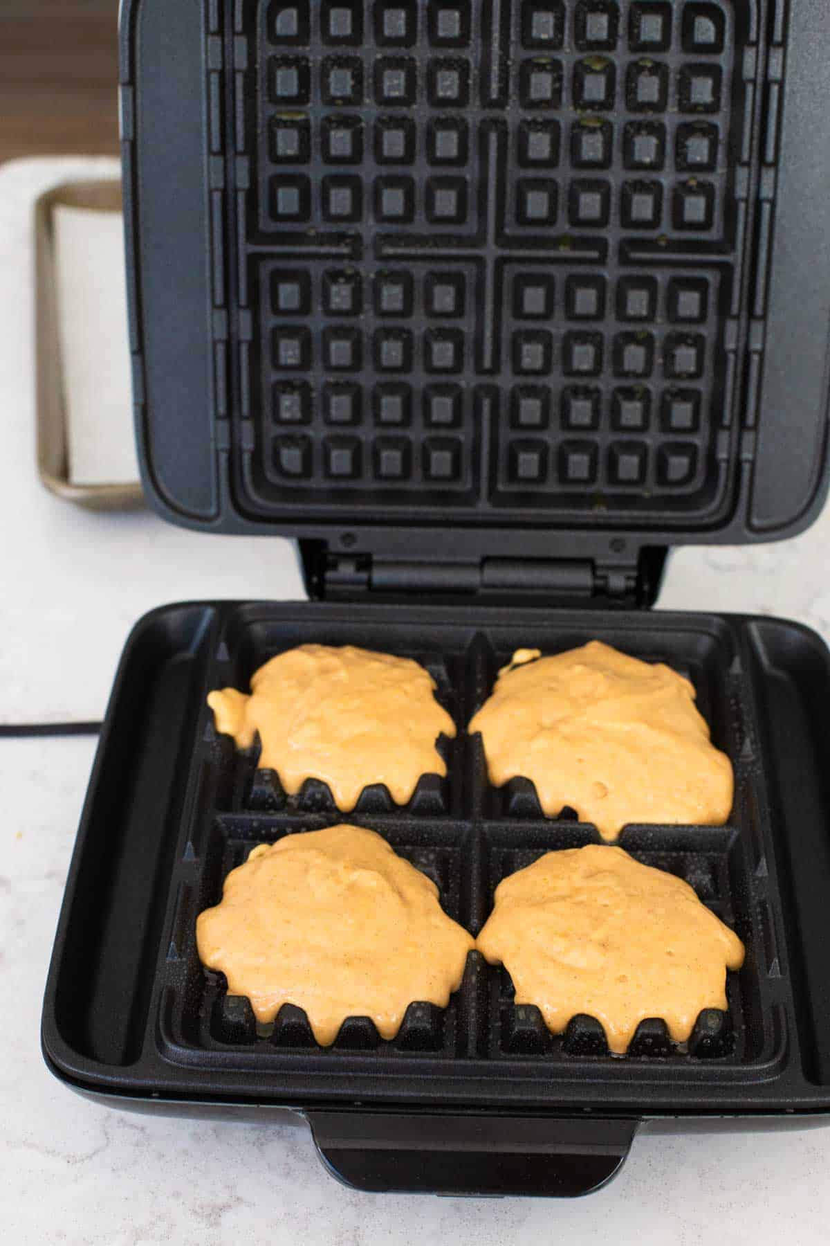 Add 1/3 cup batter to each waffle well.