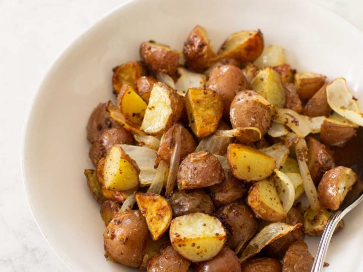 A white bowl of roasted potatoes.