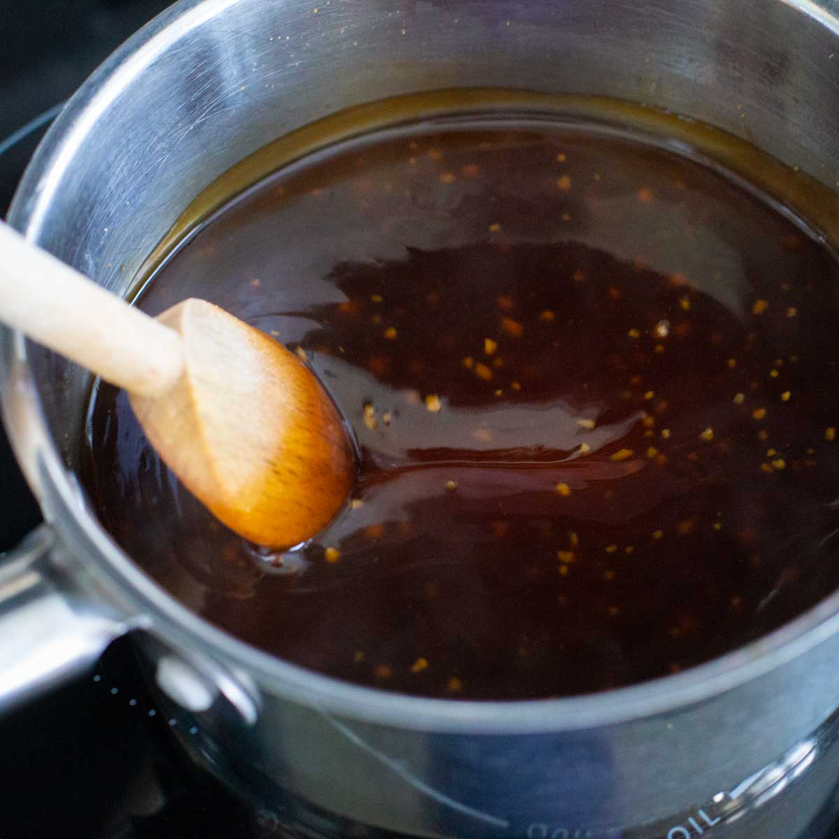 A pot of warm homemade teriyaki sauce is on the stove top.