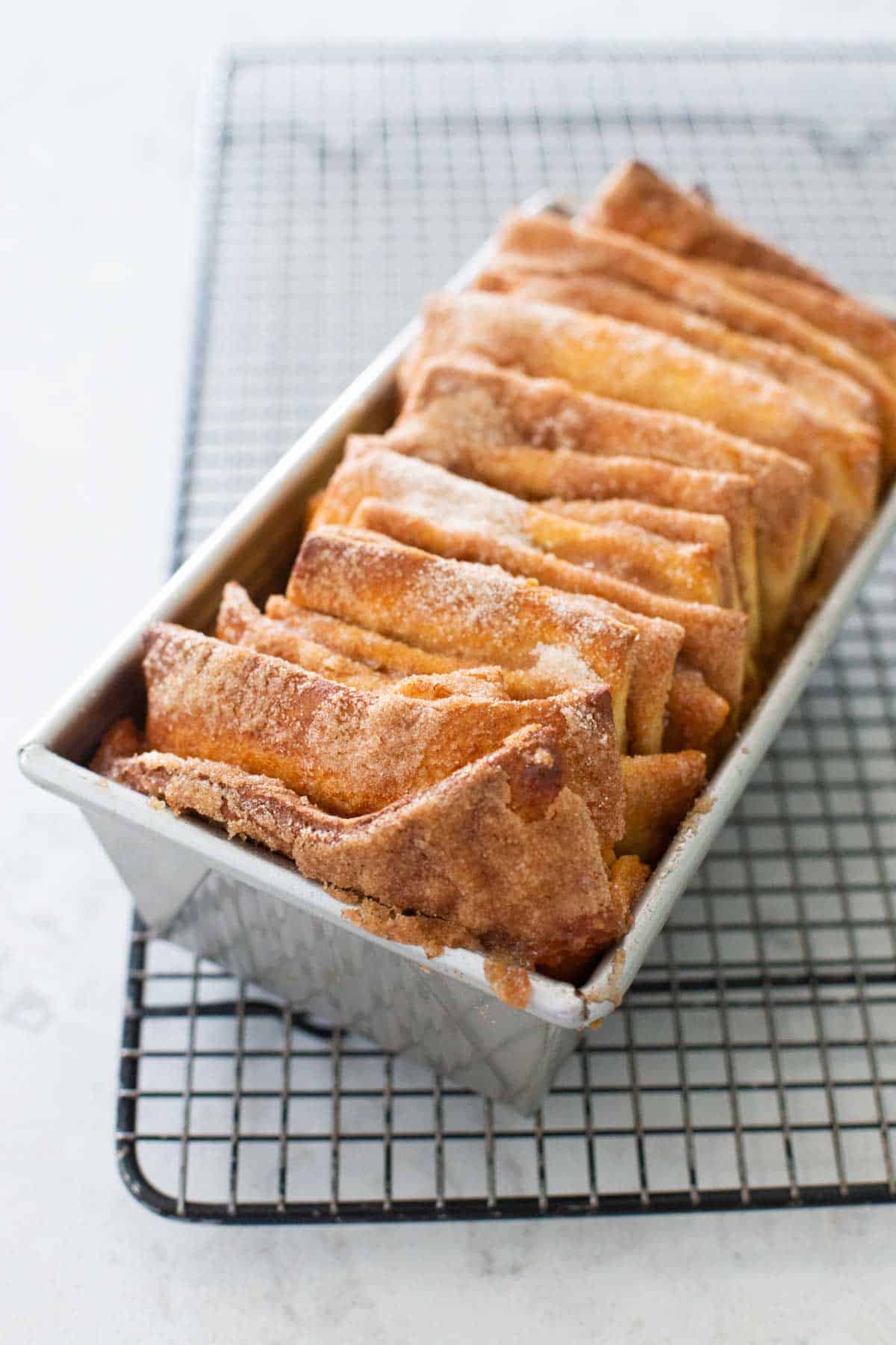 The cinnamon bread has been baked and is now cooling on a rack.