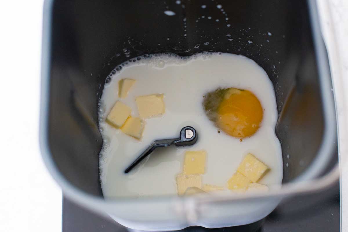 The milk, egg, and butter are in the bread pan with the paddle attachment.