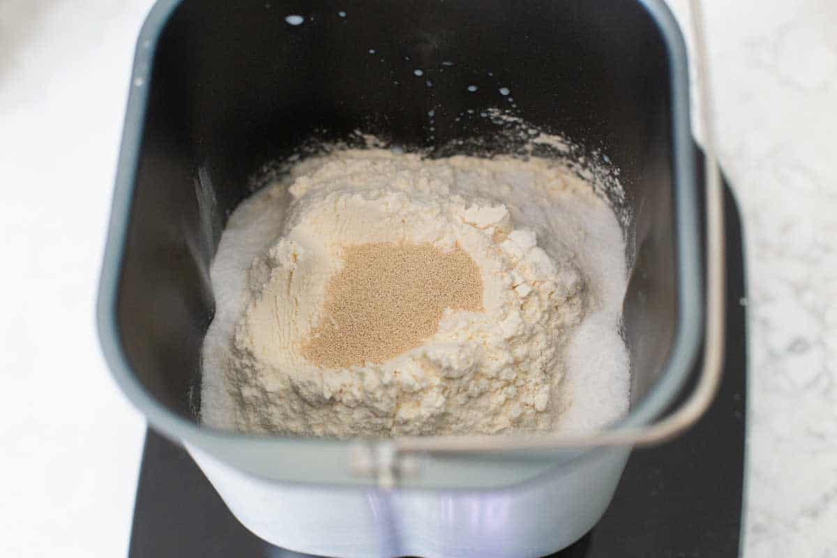 The flour, sugar, and salt are in the bread pan. The yeast is in a well in the center of the flour.