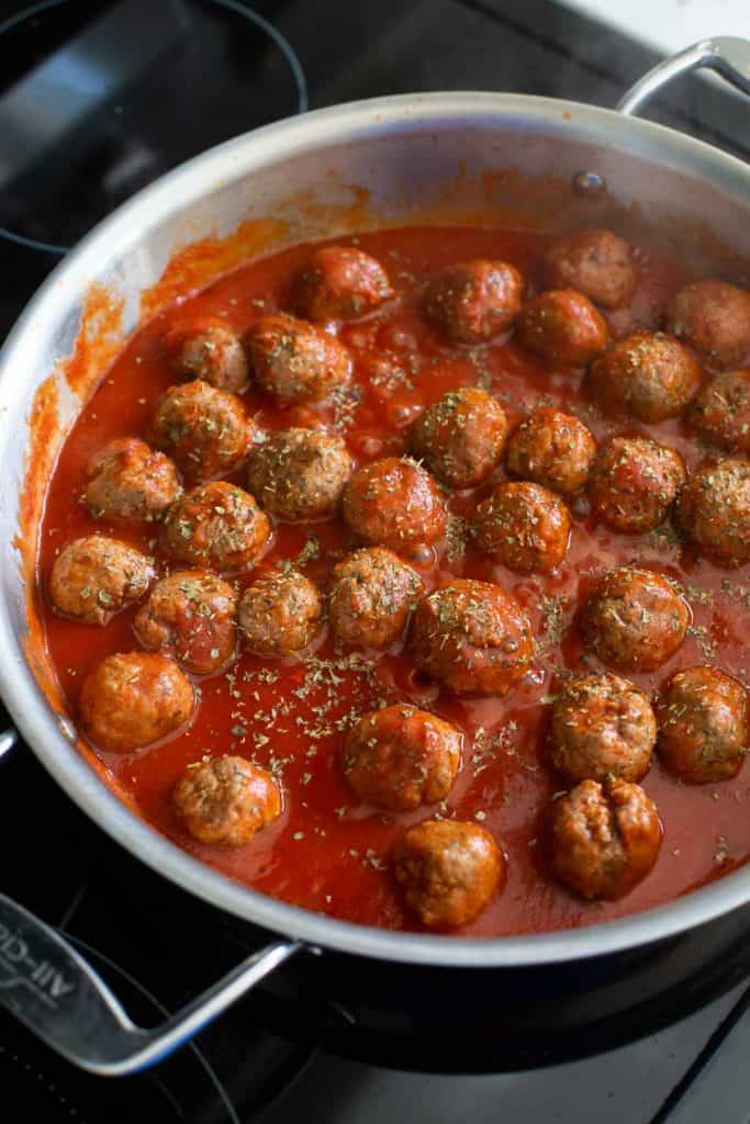 A big skillet filled with Italian meatballs and tomato sauce.