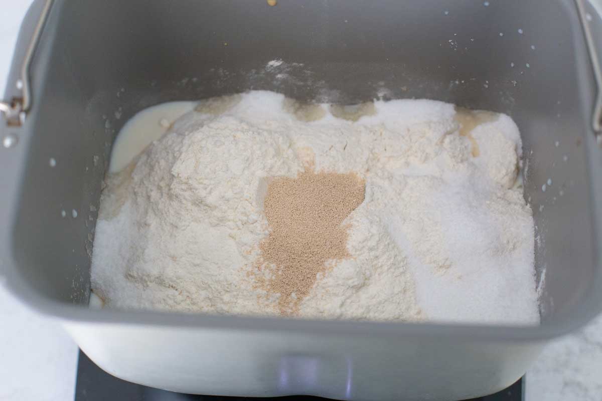 The flour, sugar, and yeast are in the bread pan.