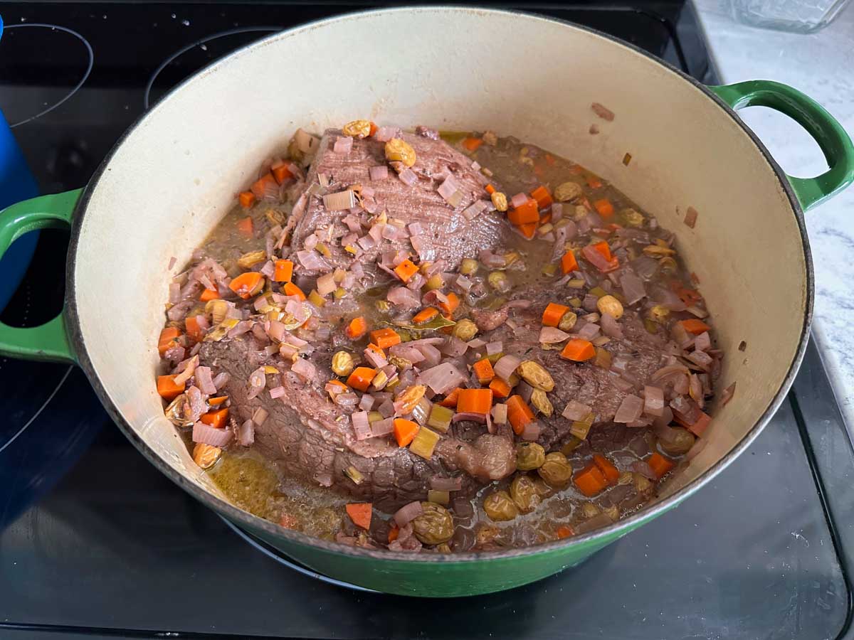 The marinade has been poured over the browned beef and is ready to cook.
