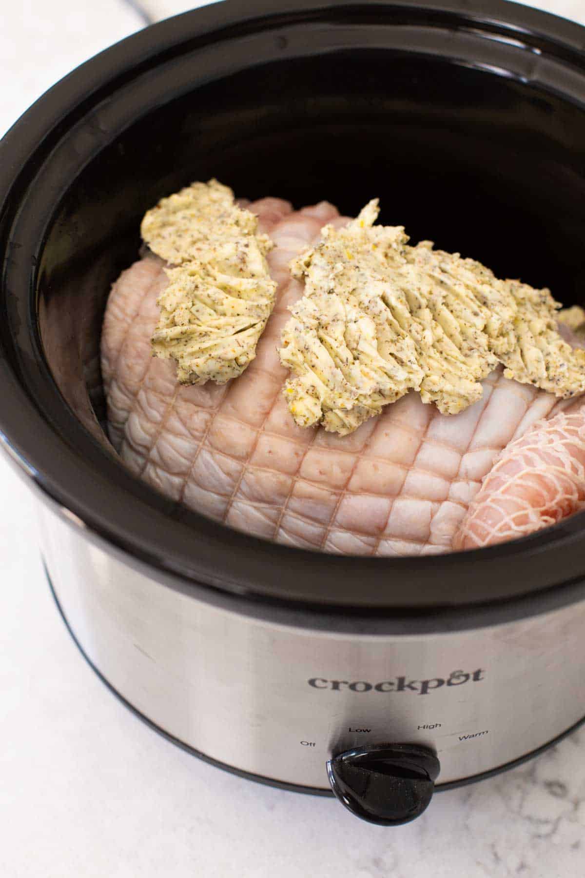 The seasoned butter has been spread on top of the turkey