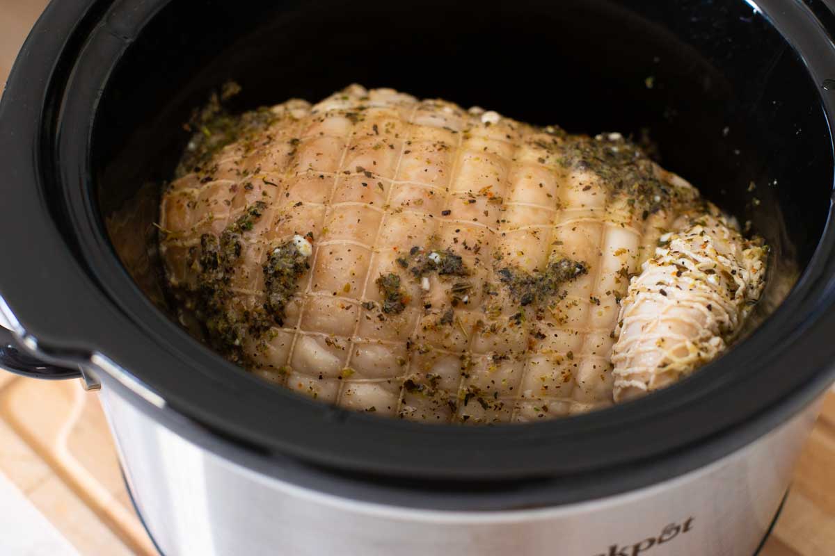 The melted butter and herbs have been basted over the top of the turkey in the Crock Pot