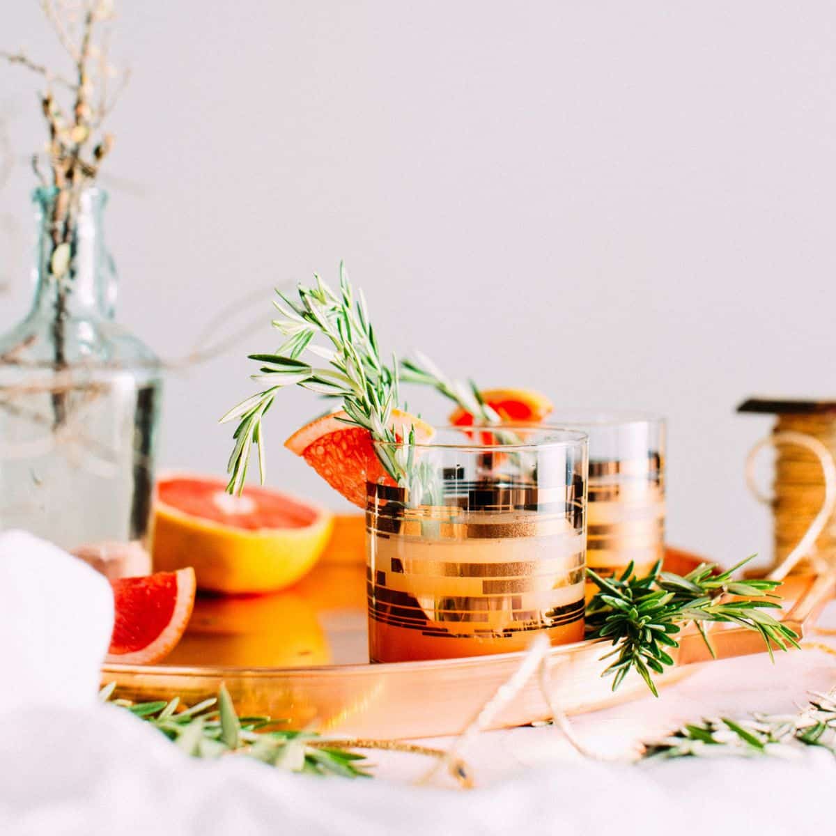 A cocktail tray with oranges and rosemary.