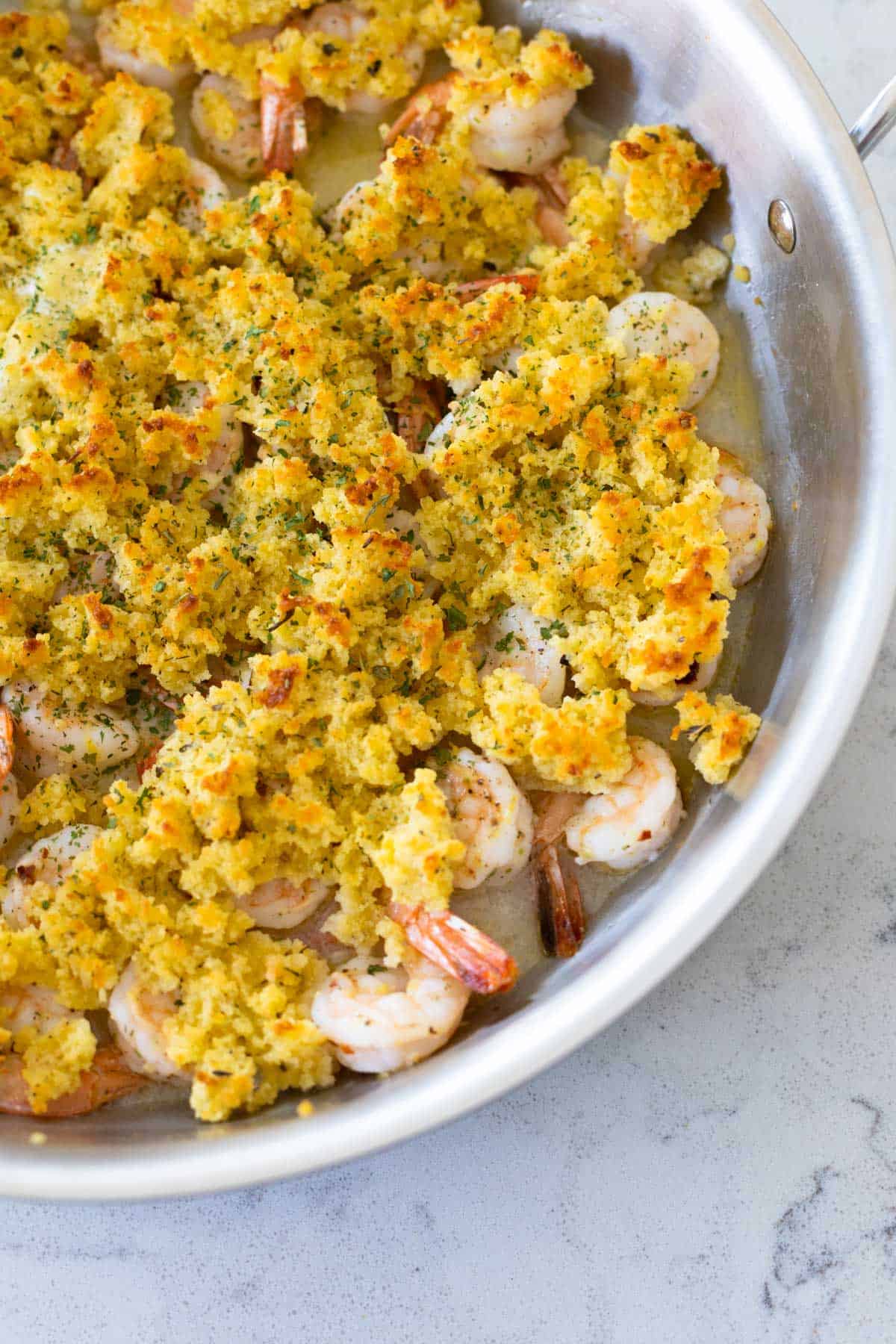 The skillet shows a close-up of the golden brown breadcrumbs.