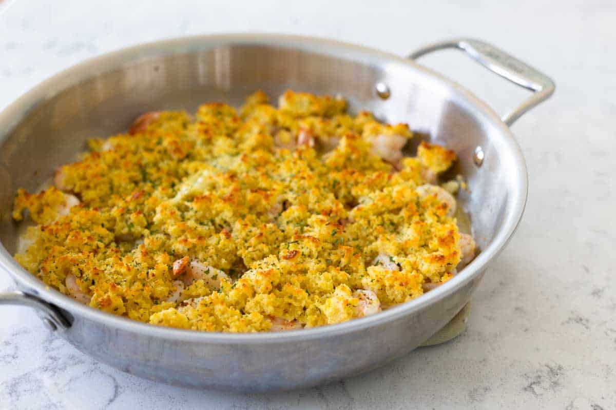 The skillet has been baked until the breadcrumb topping is golden brown.