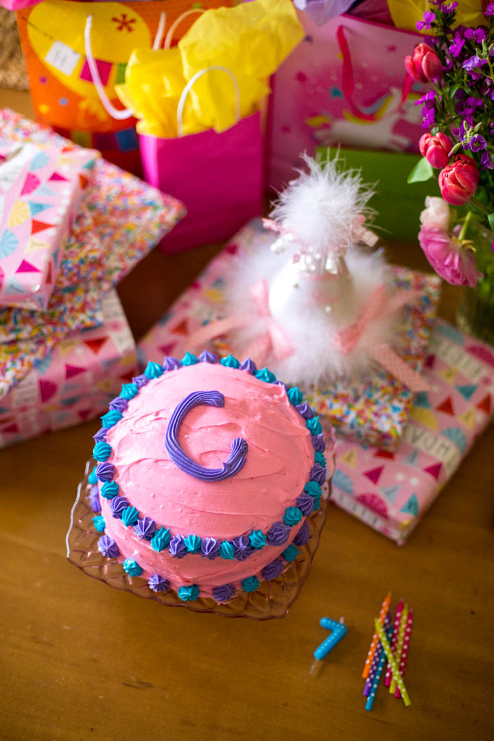 A pink cake with the letter C on top.