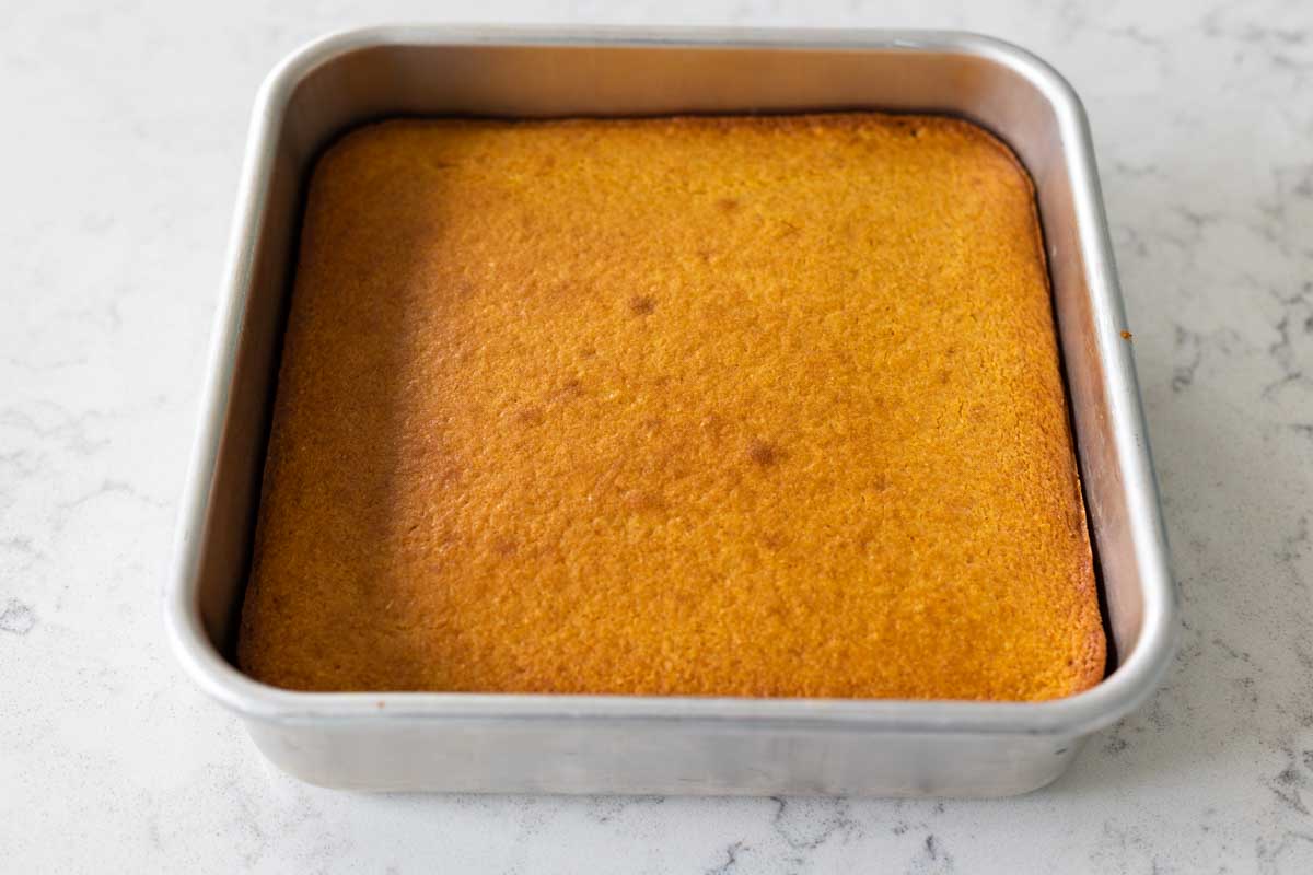 The finished buttermilk cornbread is golden brown and level in the baking pan.
