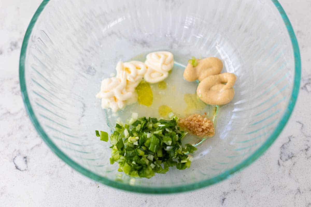 The green onions and dressing ingredients are in a big mixing bowl.