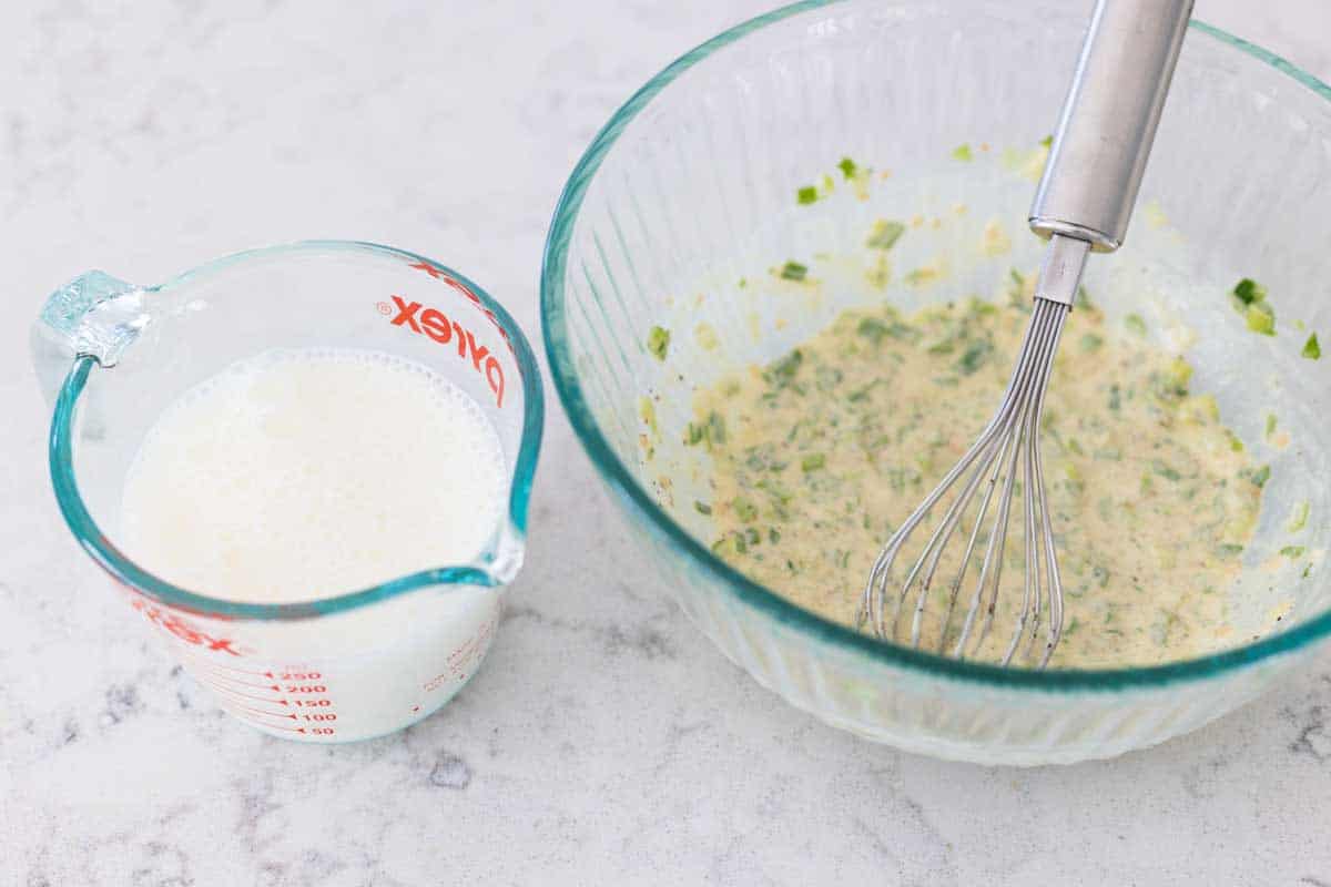 The dressing has been whisked and the cup of buttermilk is about to be drizzled in.