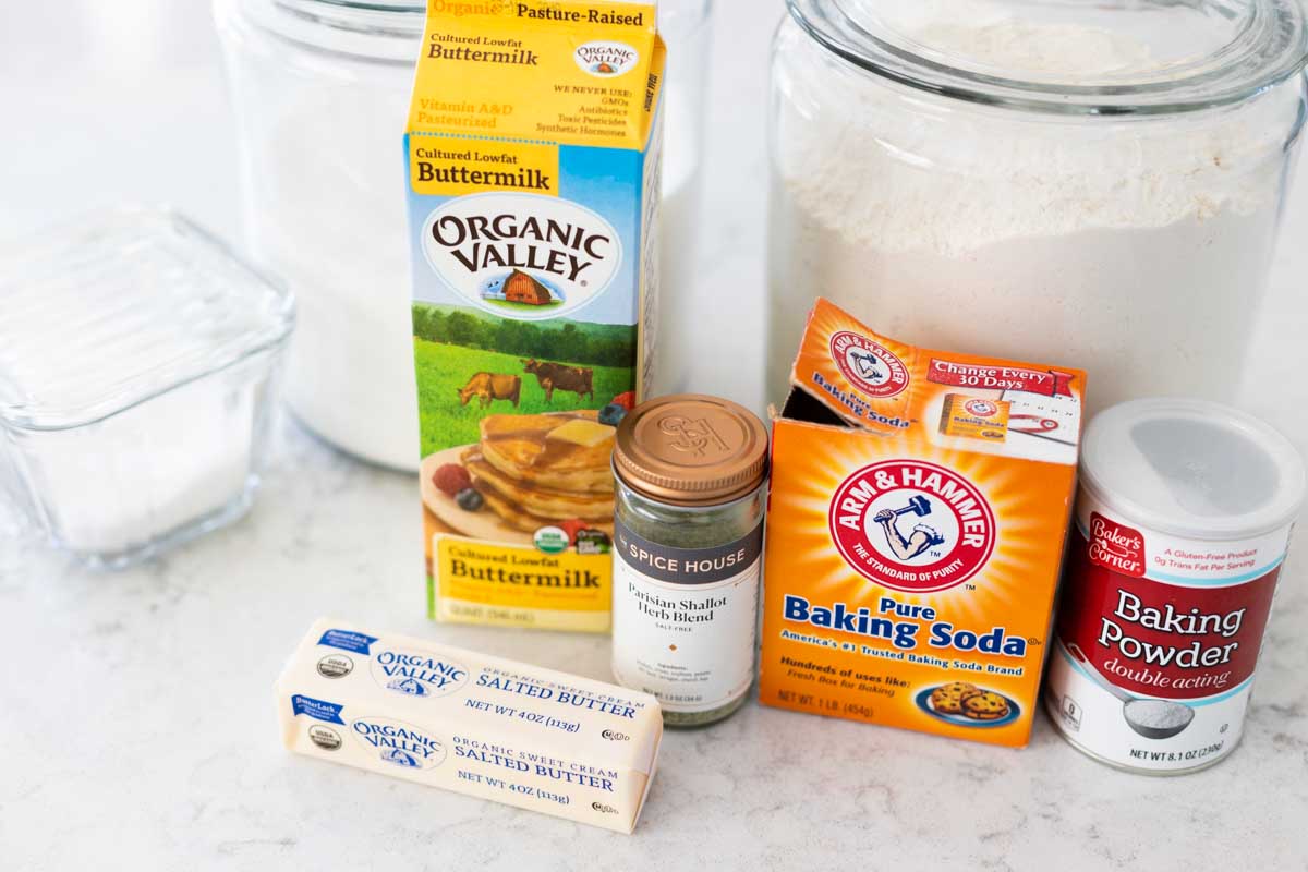The buttermilk, butter, flour, sugar, baking powder, and baking soda are on the counter.
