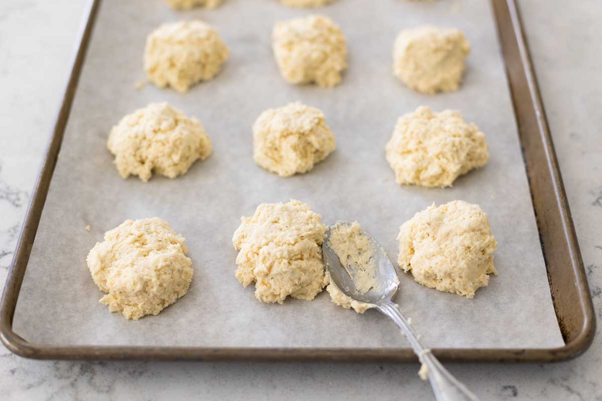 The biscuit dough has been dropped onto the baking pan using a large table spoon. 