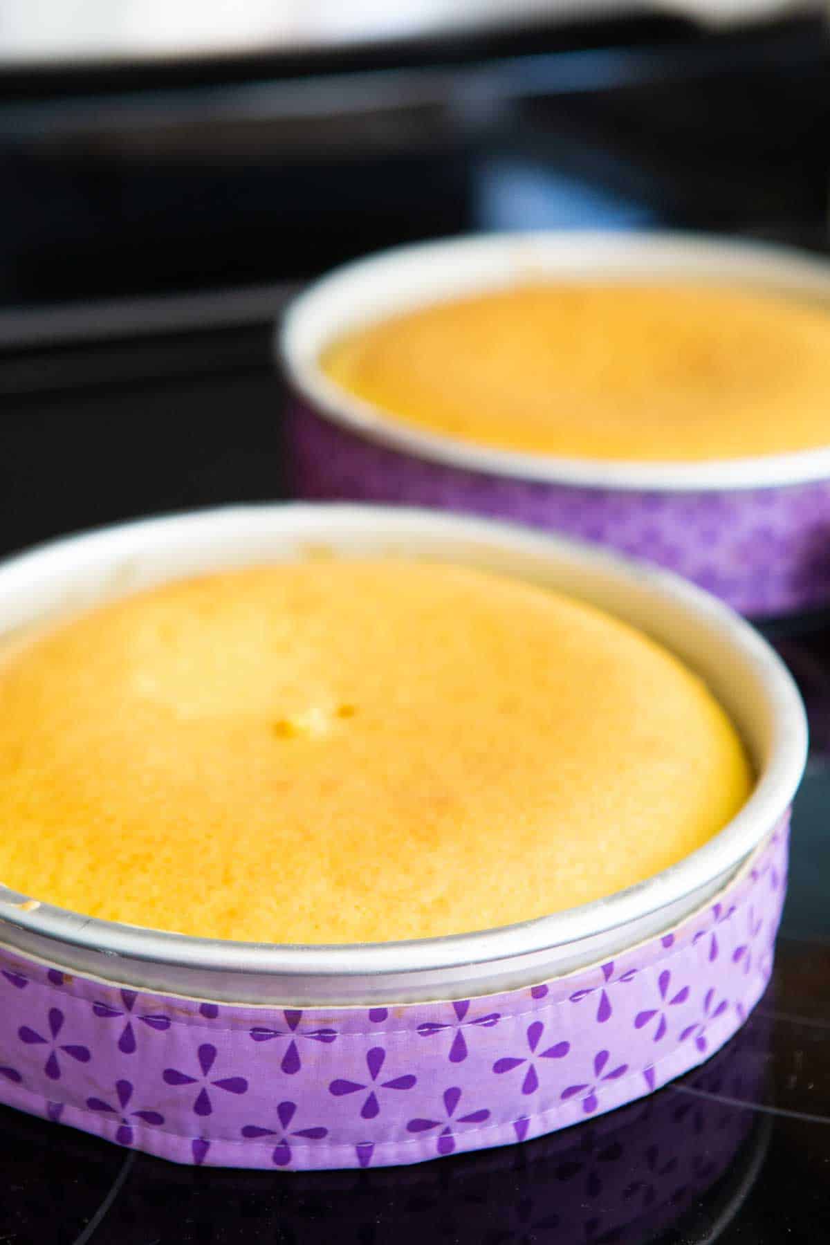 The finished baked cake layers are cooling on the stovetop.