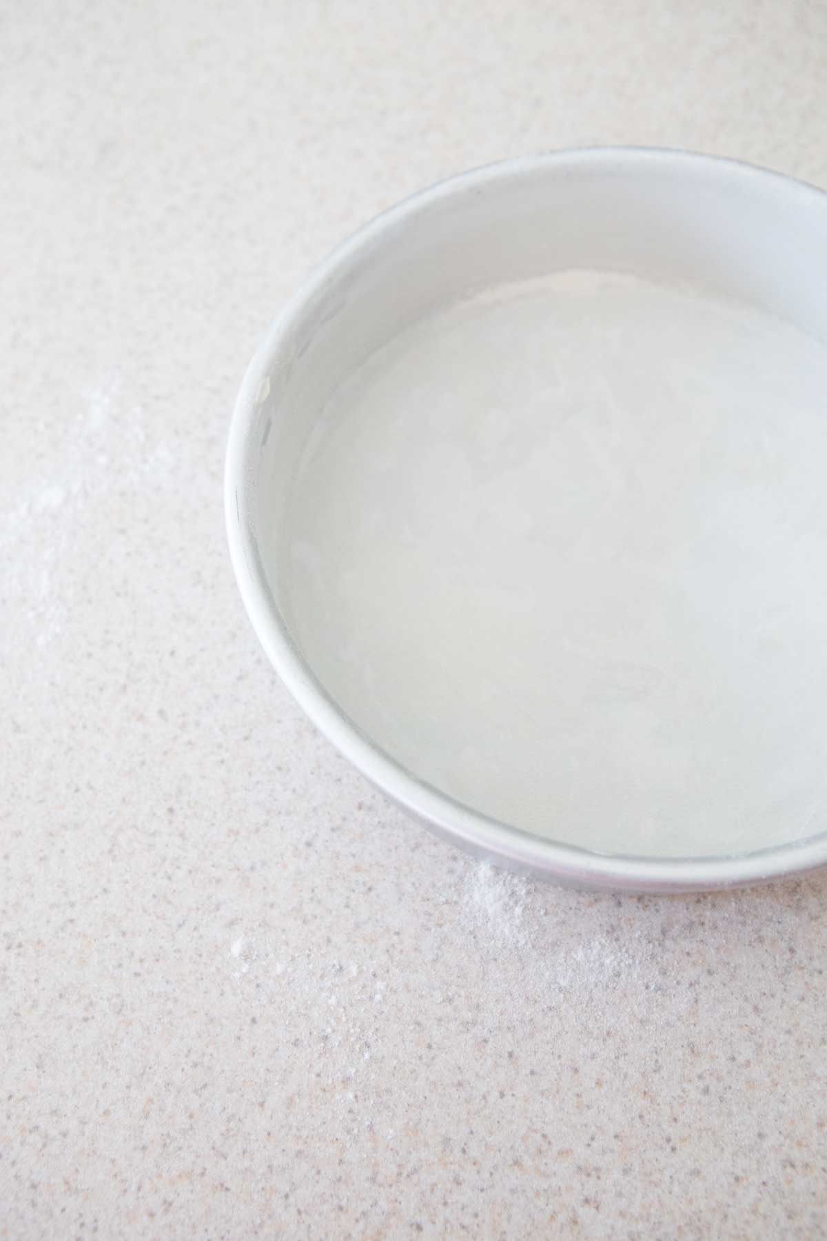 The parchment paper has been added to the bottom fo the pan and the whole thing dusted with flour.