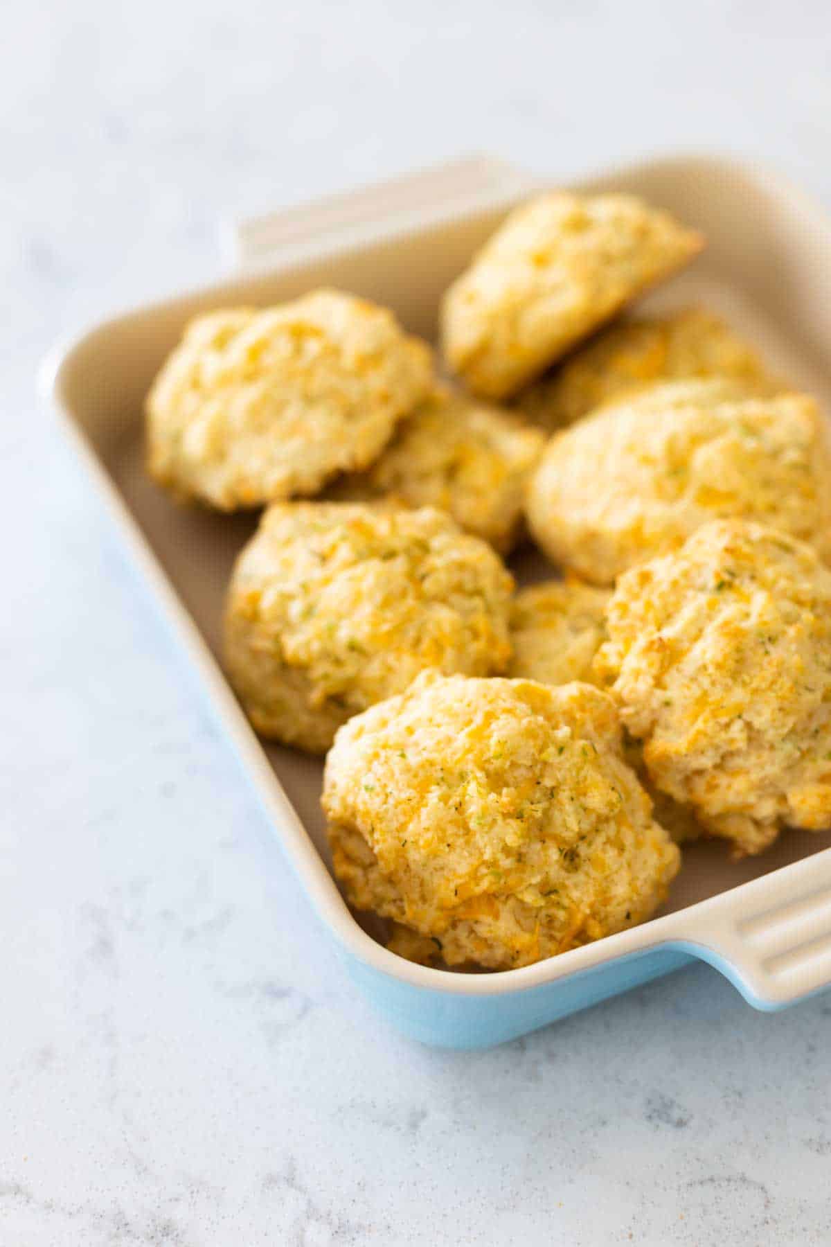 A blue dish is filled with baked biscuits.