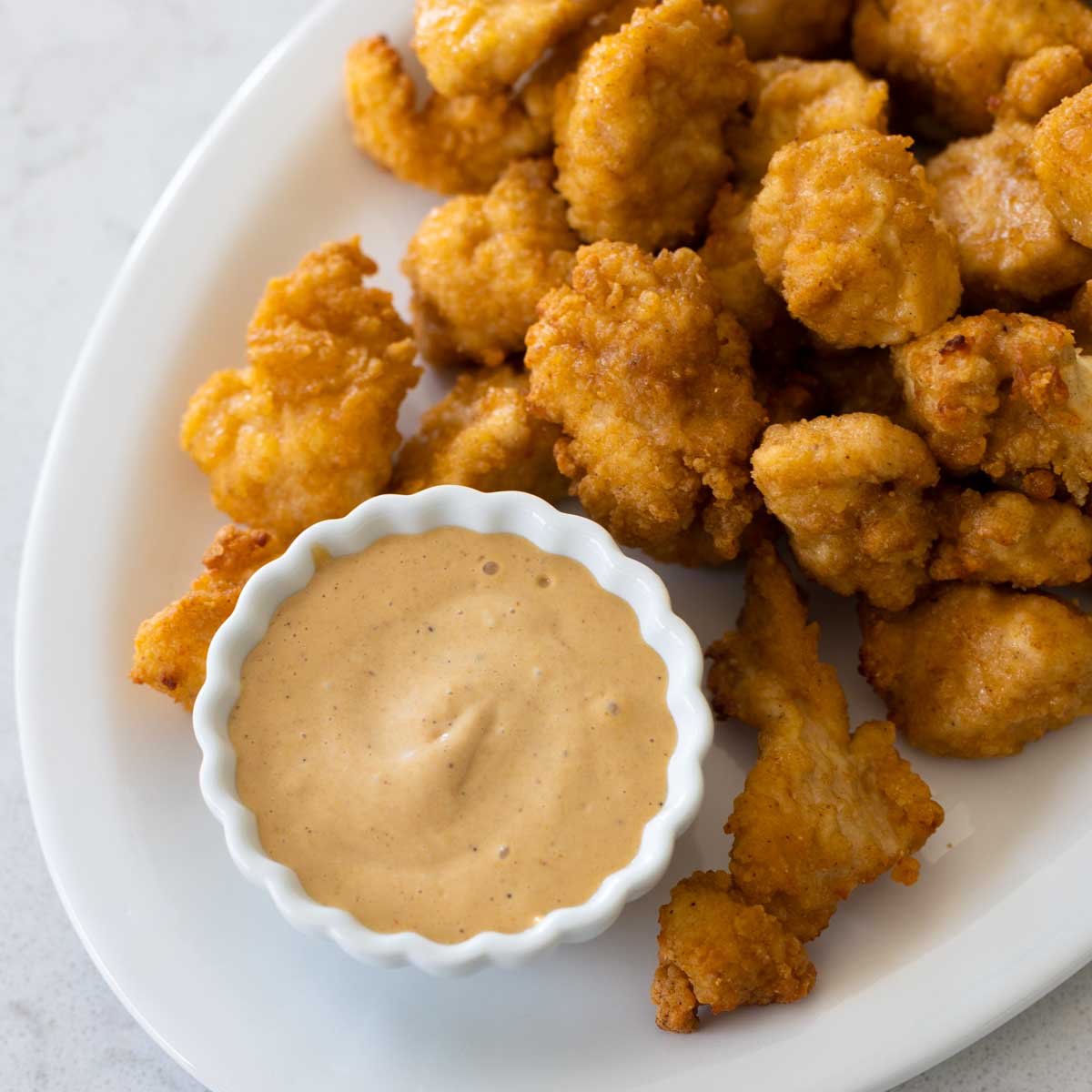 A platter of chicken nuggets has a cup of copycat Chick-Fil-A sauce for dunking.