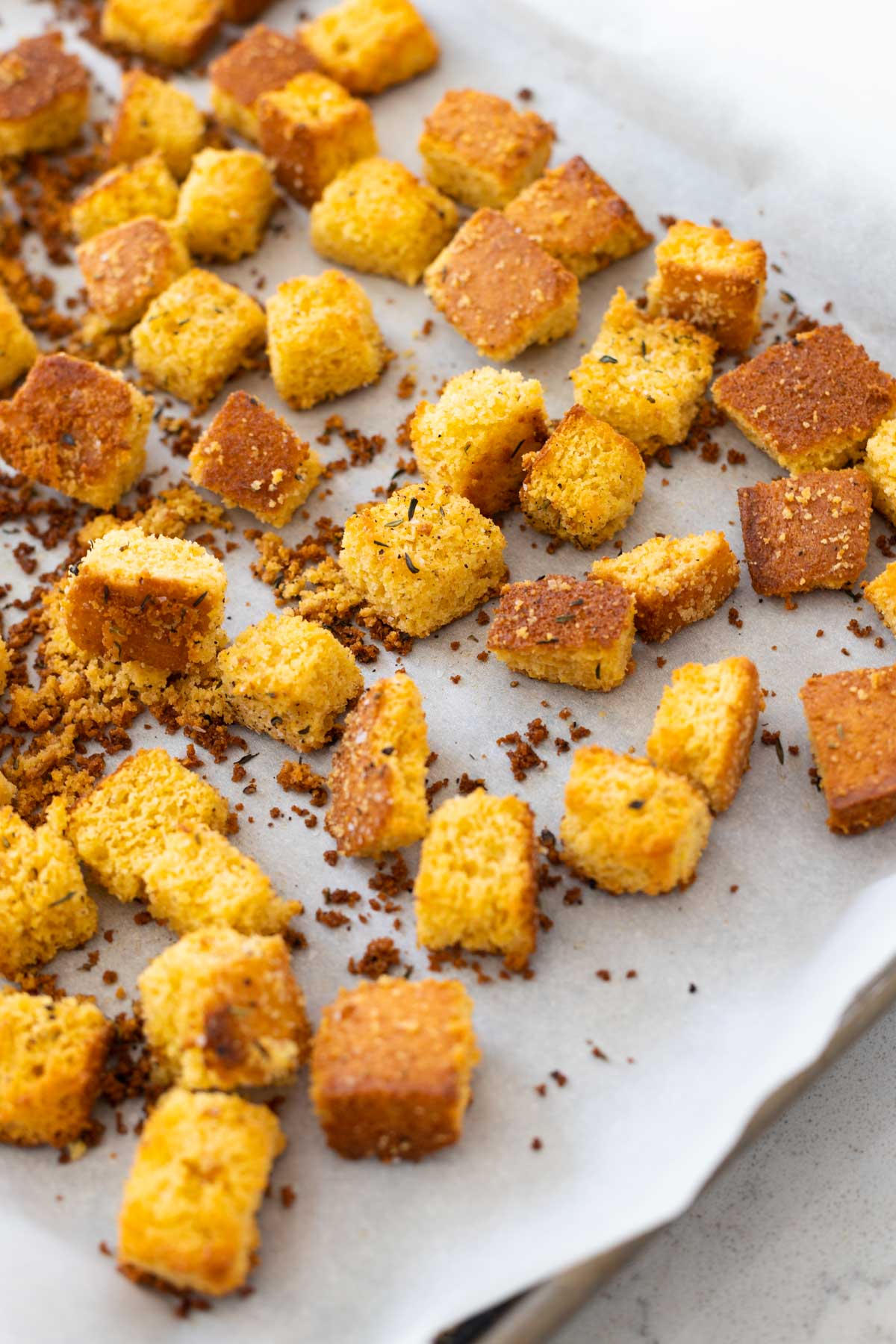 The finished cornbread croutons are cooling on the baking sheet.