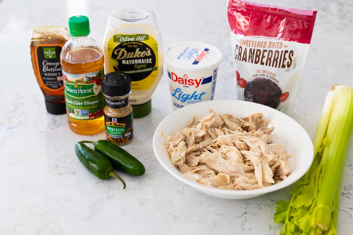 The ingredients to make a homemade chicken salad are on the counter.