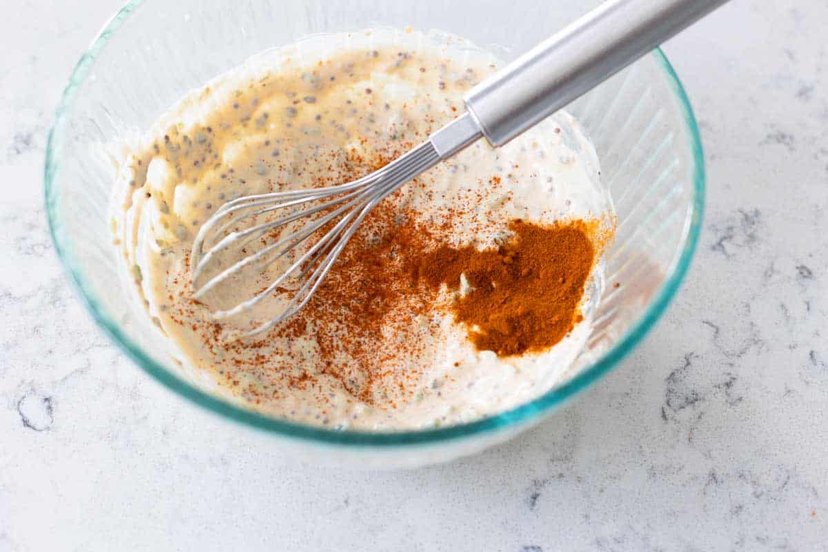 The ingredients have been whisked together and now dried seasonings are sprinkled over the top.