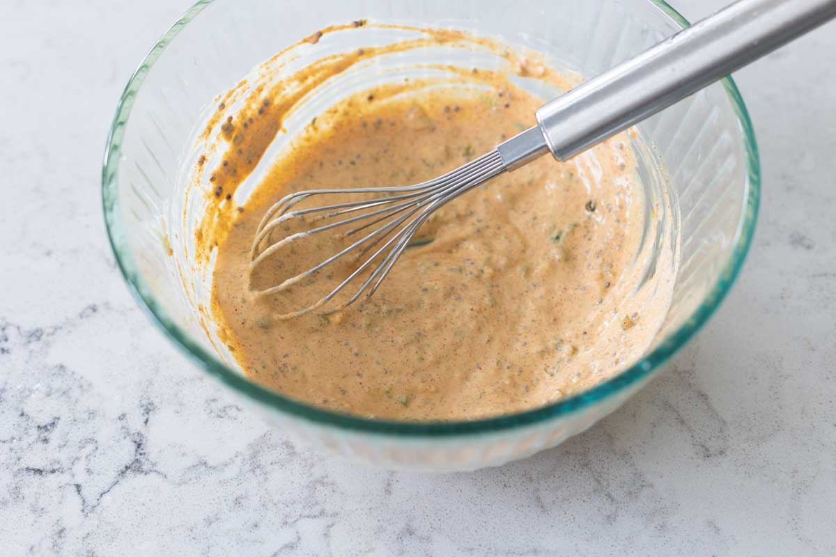 The spicy Remoulade Sauce has finished being whisked in the bowl.