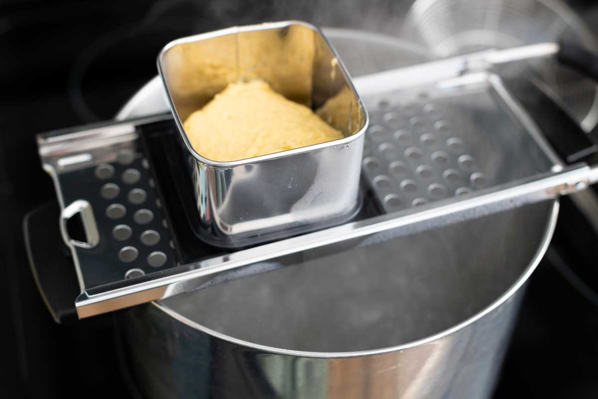 The dough is in the maker over a pot of boiling water.