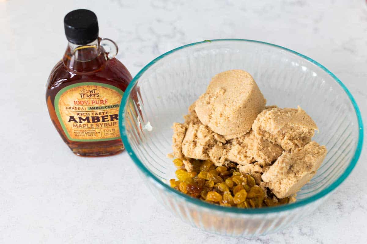 The brown sugar, golden raisins, and maple syrup on the counter.