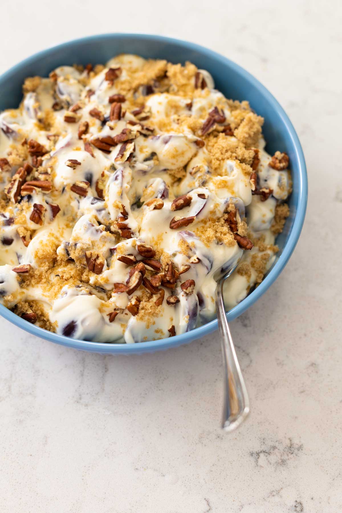 The grape salad has been topped with crumbled brown sugar and chopped pecans. 