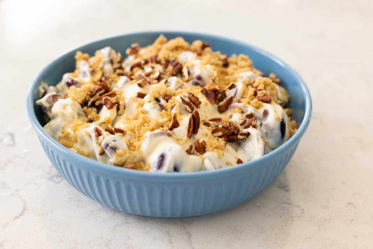 The copycat Chicken Salad Chick grape salad is in a blue bowl on the counter.